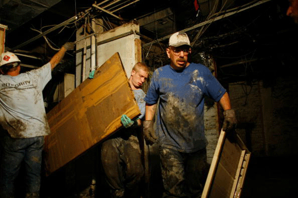 Workers clean out the basement of an office building after the Cedar River inundated it with flood waters June 22 2008 in Cedar Rapids Iowa