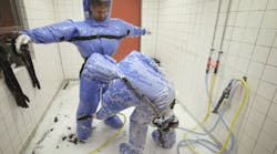 A doctor for tropical medicine and a nurse demonstrate the decontamination procedure as part of ebola treatment at Station 59 at Charite hospital on August 11, 2014 in Berlin, Germany. The specialized quarantine unit at Station 59 is among a handful of facilities in Germany nationwide that are capable of handling ebola cases. (Photo by Sean Gallup/Getty Images)