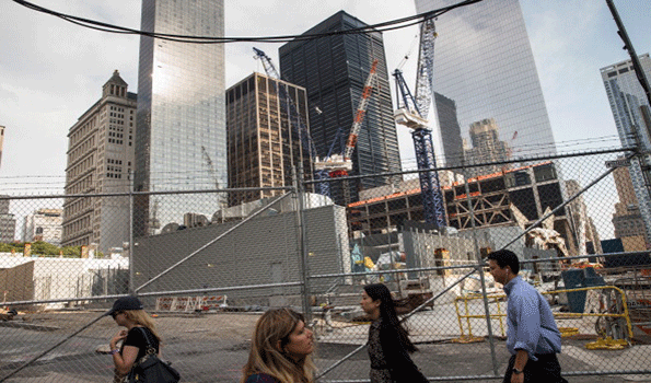 People walk along the northern edge of the Ground Zero construction zone on June 24 2013 in New York City Construction is ongoing on the surrounding complex