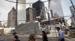 People walk along the northern edge of the Ground Zero construction zone on June 24, 2013 in New York City. Construction is ongoing on the surrounding complex.