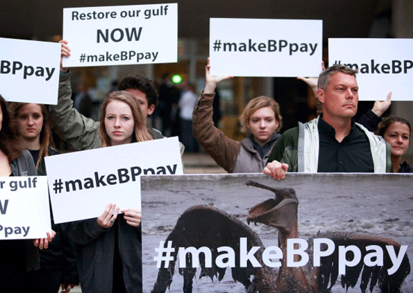 Activists holds signs during a protest in front of the Hale Boggs Federal Building on the first day of the trial over the Deep Water Horizon oil rig spill on Feb 25 2013 in New Orleans Eleven men were killed during the accident and over 4 million barrels of oil spilled into the Gulf of Mexico in 2010