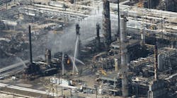 Emergency crews struggle to put out the fire from a blast that killed 15 workers and injured nearly 200 more at BP&apos;s Texas City, Tex., oil refinery on March 23, 2005.