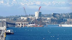 With the Olympic Mountains in the background, construction on the West Connection Bridge progresses on Lake Washington in Seattle. Once complete, the bridge will connect the new floating bridge to the existing SR 520 west approach.