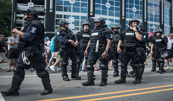 Police in riot gear walk outside Bank of America Stadium before an NFL football game between the Charlotte Panthers and the Minnesota Vikings Sept 25 in Charlotte NC