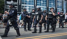 Police in riot gear walk outside Bank of America Stadium before an NFL football game between the Charlotte Panthers and the Minnesota Vikings Sept. 25 in Charlotte, N.C.
