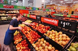 A WalMart associate stocks produce in a WalMart Supercenter store A WalMart associate stocks produce in a WalMart Supercenter store