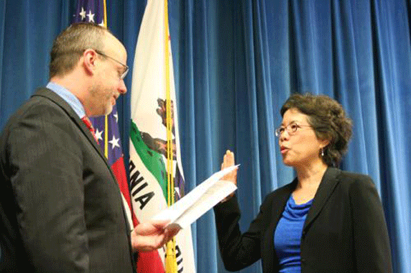 Juliann Sum receive the oath of office from California Labor Secretary David Lanier.