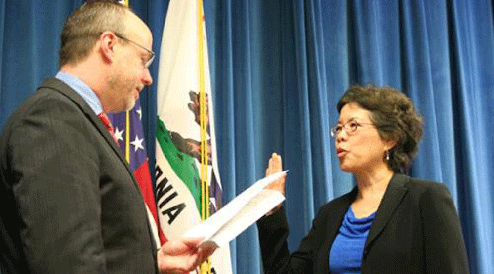Juliann Sum receive the oath of office from California Labor Secretary David Lanier.