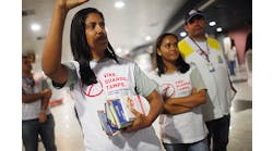 Health workers pass out information on mosquito protection to people arriving in the baggage claim area at Guararapes Gilberto Freyre International Airport on Feb. 4 in Recife, Pernambuco state, Brazil. Officials say as many as 100,000 people may have already been exposed to the Zika virus in Recife.