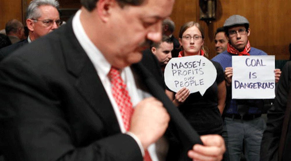 Protesters Kate Rooth and Oscar Ramirez hold signs after Don Blankenship (left), former chairman and CEO of Massey Energy, testified for a hearing before the Labor, Health and Human Services, Education and Related Agencies Subcommittee of the Senate Appropriations Committee May 20, 2010 on Capitol Hill in Washington, DC. The hearing was to examine issues regarding the safety of coal mining.