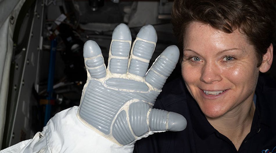 NASA astronaut Anne McClain displays a spacesuit glove that is part of an Extravehicular Mobility Unit, or spacesuit, worn during U.S. spacewalks.
