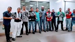 Employees at a meeting on hand safety received foam baseball mitts