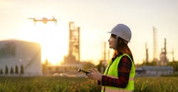 Drone flying over oil refinery plant during site survey. Drone flying over oil refinery plant during site survey.