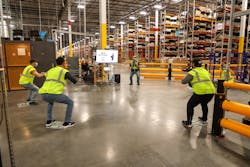 Amazon employees participate in a Health &amp; Safety Huddle. For many Amazon employees, this is the first time they are working in a physical role.