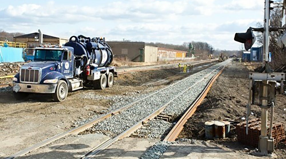 A liquid containment rig helps crews remove standing water from the derailment site to prevent runoff.