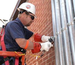 Worker at height using a snap on tool, an example of good fall protection and PPE program Worker at height using a snap on tool, an example of good fall protection and PPE program