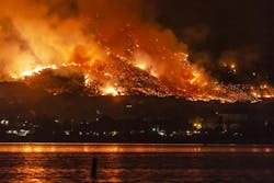 photo of a body of water in the forefront and a wildfire burning in the distance photo of a body of water in the forefront and a wildfire burning in the distance