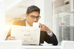 man in business suit drinking coffee and reading a newspaper man in business suit drinking coffee and reading a newspaper