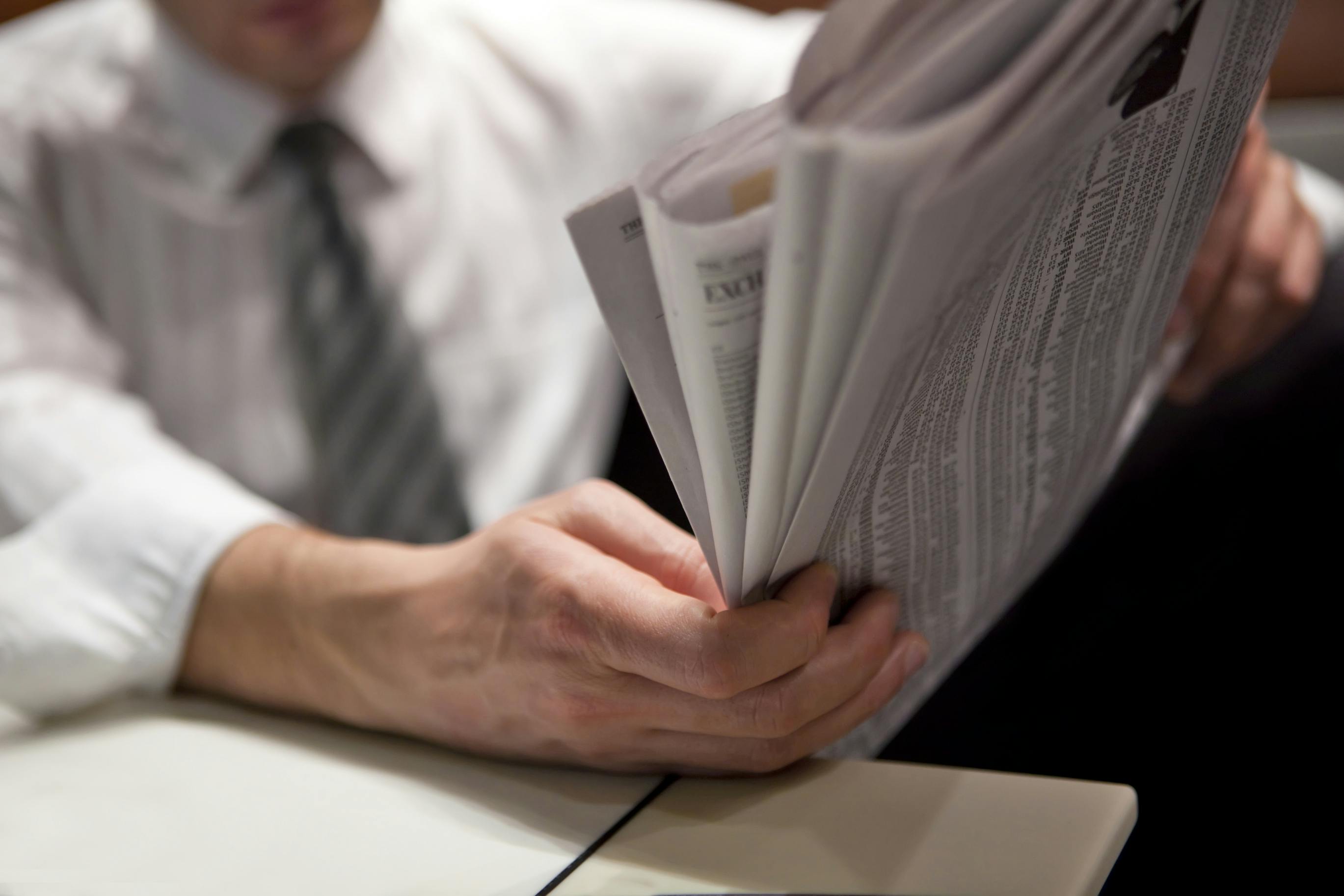 man in business attire reading newspaper