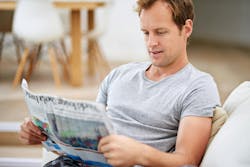 man sitting on couch reading newspaper man sitting on couch reading newspaper
