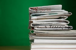 stack of newspapers and magazines against a green background stack of newspapers and magazines against a green background