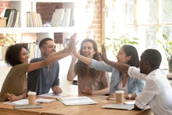 5 co-workers sitting around a table clapping their hands as a sign of teamwork and comraderie 5 co-workers sitting around a table clapping their hands as a sign of teamwork and comraderie