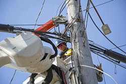 lineman working out in the field on electrical wires at height in a cherry picker lineman working out in the field on electrical wires at height in a cherry picker