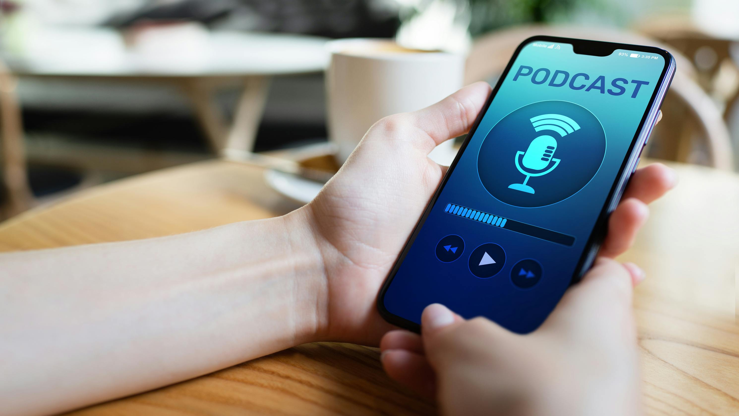 person holding smartphone with screen that shows podcast playing