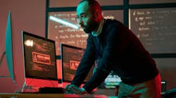 man standing and leaning over to look at computer screens that read 'Critical Error' man standing and leaning over to look at computer screens that read 'Critical Error'