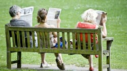 picture of a middle-aged man, young woman and older woman sitting on a park bench reading the newspapers with their back to the camera picture of a middle-aged man, young woman and older woman sitting on a park bench reading the newspapers with their back to the camera