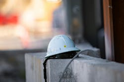 Picture of a Mips Type 2 safety helmet on a concrete ledge on a construction site Picture of a Mips Type 2 safety helmet on a concrete ledge on a construction site