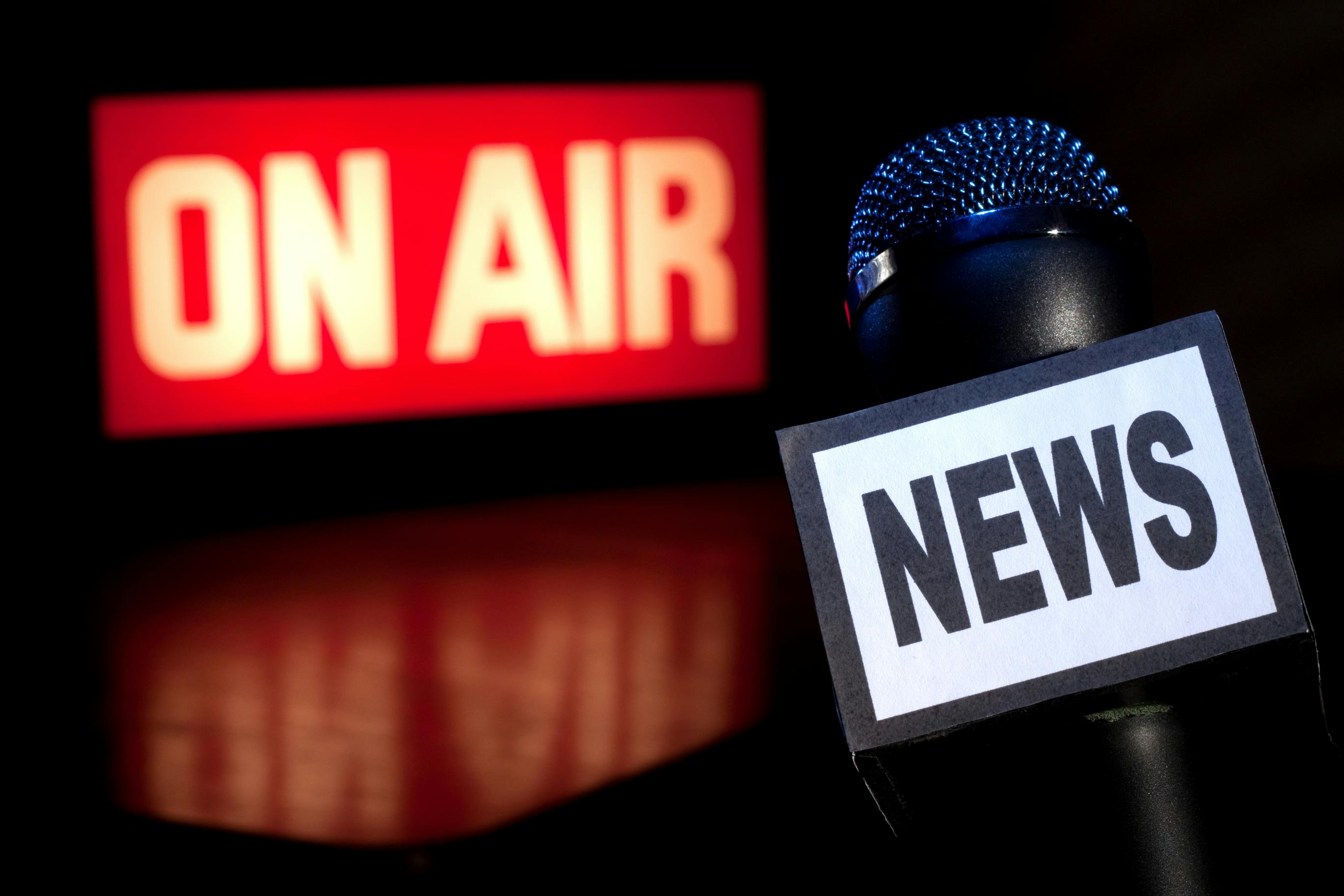 Picture of microphone next to broadcasting 'On Air' sign