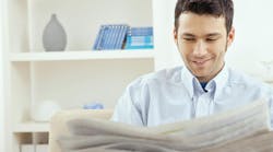 man sitting on couch reading newspaper man sitting on couch reading newspaper