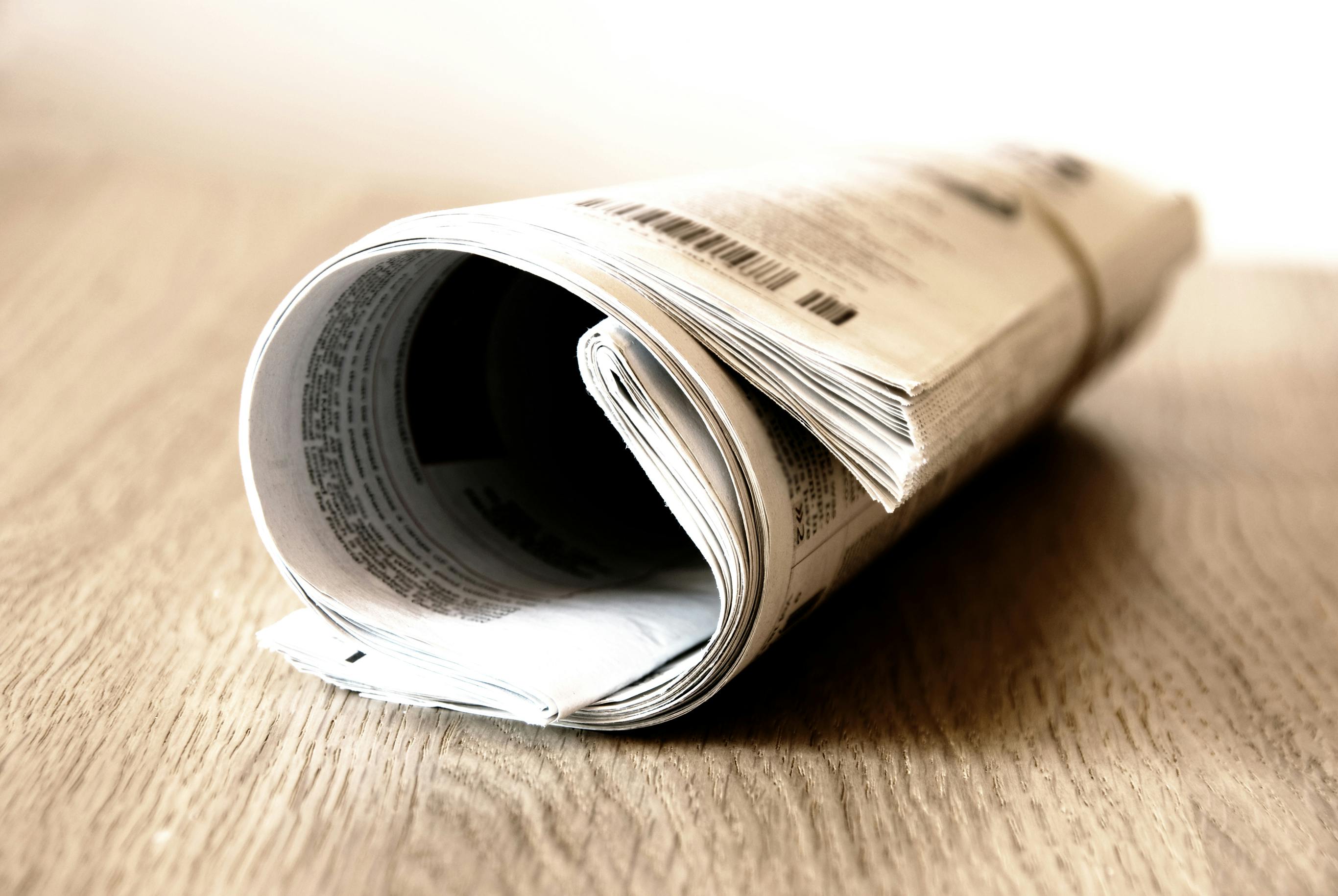 picture of rolled up newspaper on table