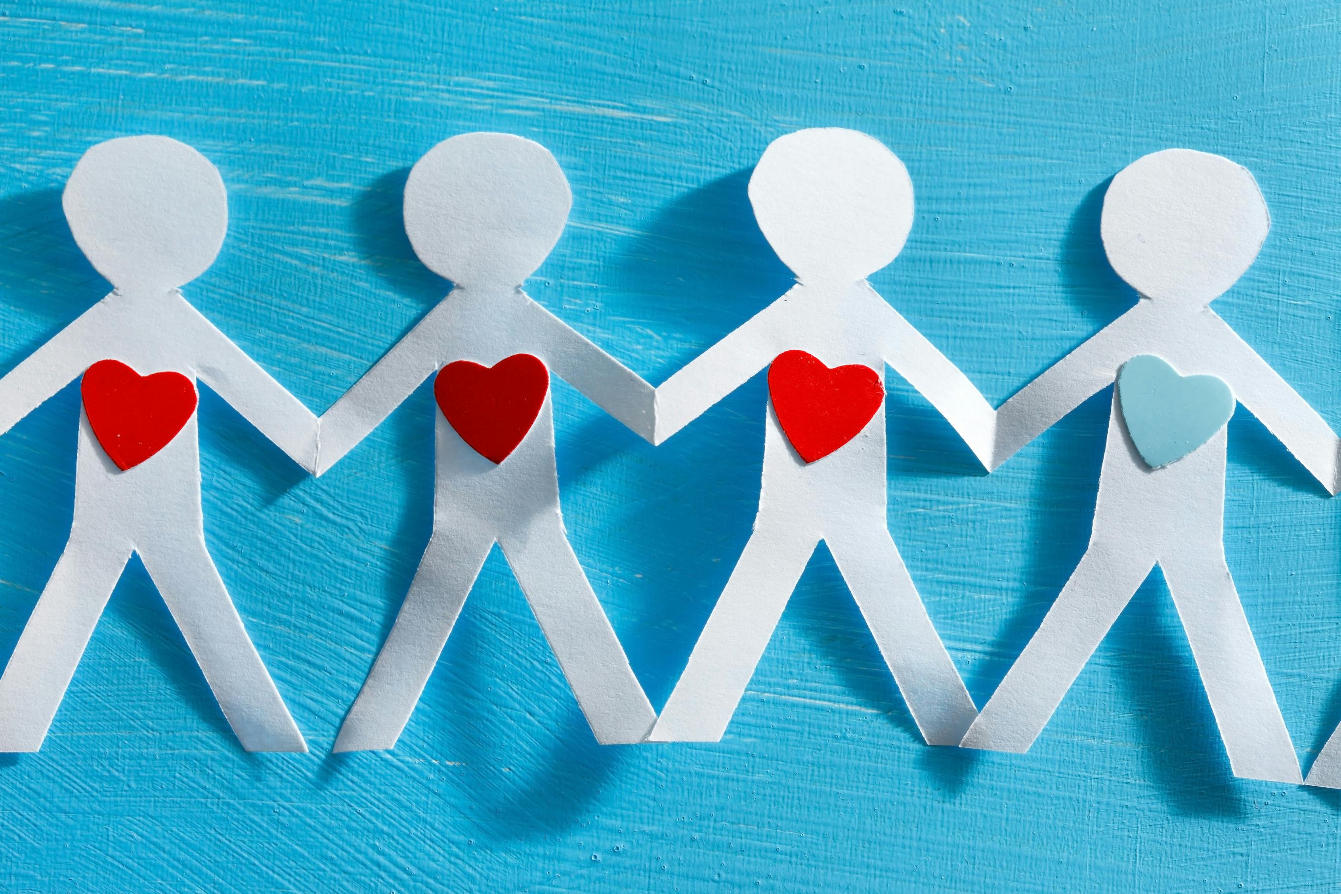 paper chain people with hearts on their chest connected to one another
