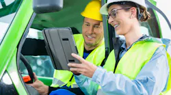 photo of male and female workers wearing hi-vis vests and hard hats looking at a tablet photo of male and female workers wearing hi-vis vests and hard hats looking at a tablet