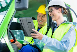 photo of male and female workers wearing hi-vis vests and hard hats looking at a tablet photo of male and female workers wearing hi-vis vests and hard hats looking at a tablet