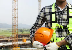 picture of construction worker wearing hi-vis vest and gloves holding a hard hat picture of construction worker wearing hi-vis vest and gloves holding a hard hat