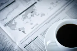 picture of coffee cup and saucer on top of a newspaper