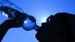 silhouette of woman drinking water against a blue sky, representing heat wave and OSHA's new proposed heat safety standard