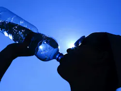 silhouette of woman drinking water against a blue sky, representing heat wave and OSHA's new proposed heat safety standard